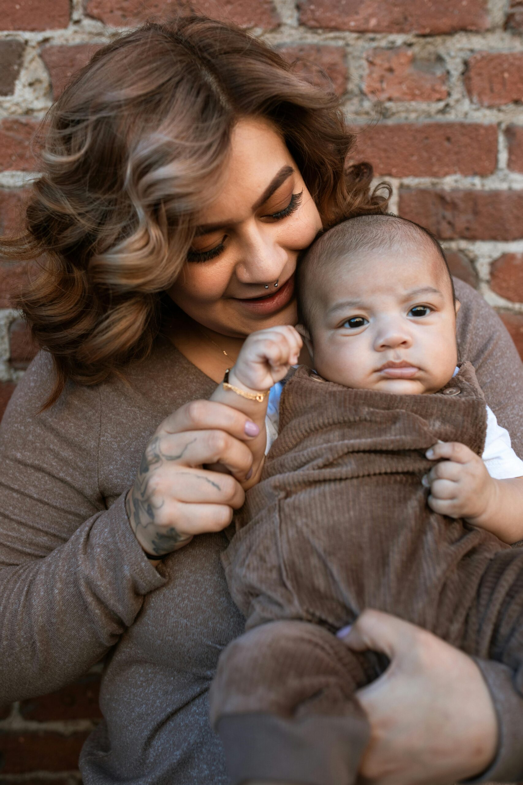 mom with brown hair holding baby